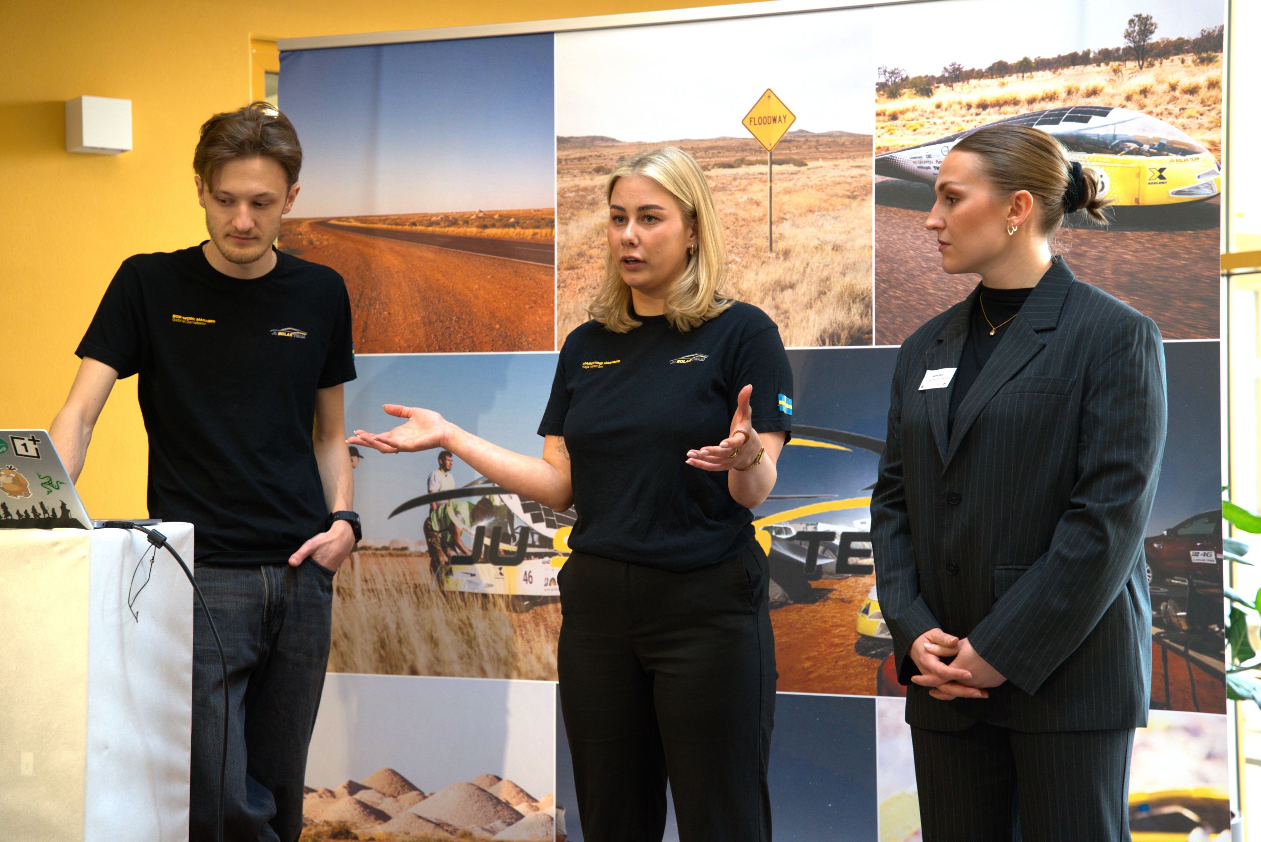 Tre studenter på scen.