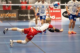 Girl in a red ski suit on ski slope.